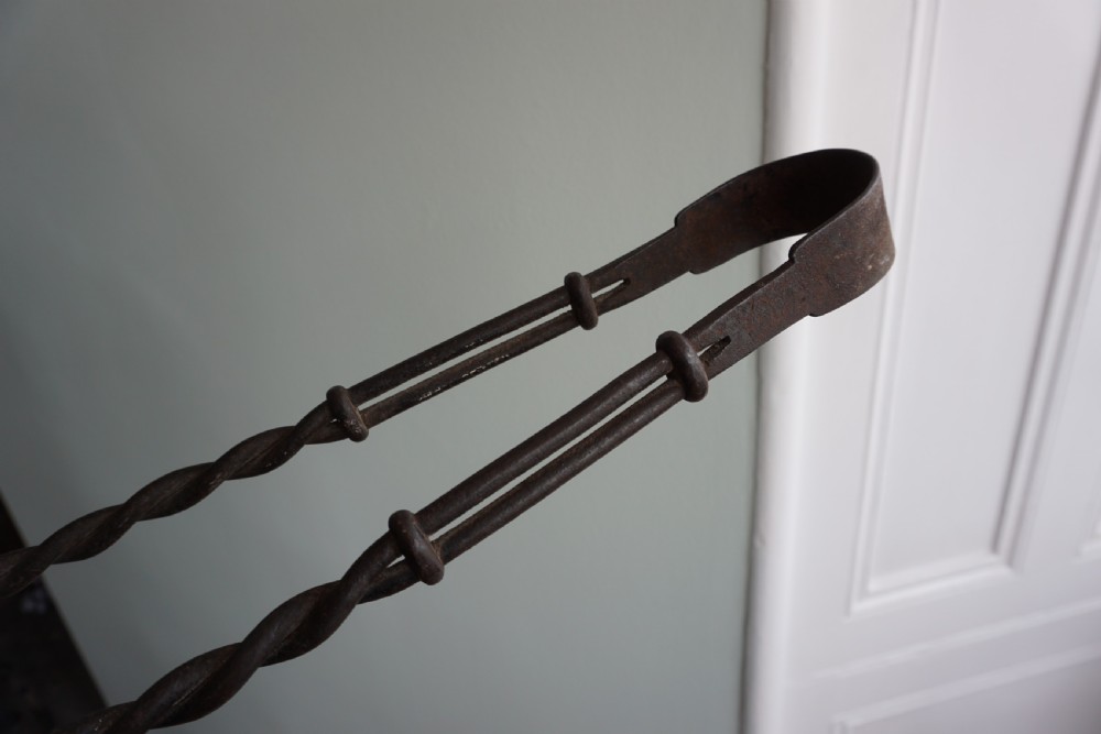 An interesting pair of wrought iron fire tongs, probably late 17th or early 18th century View II