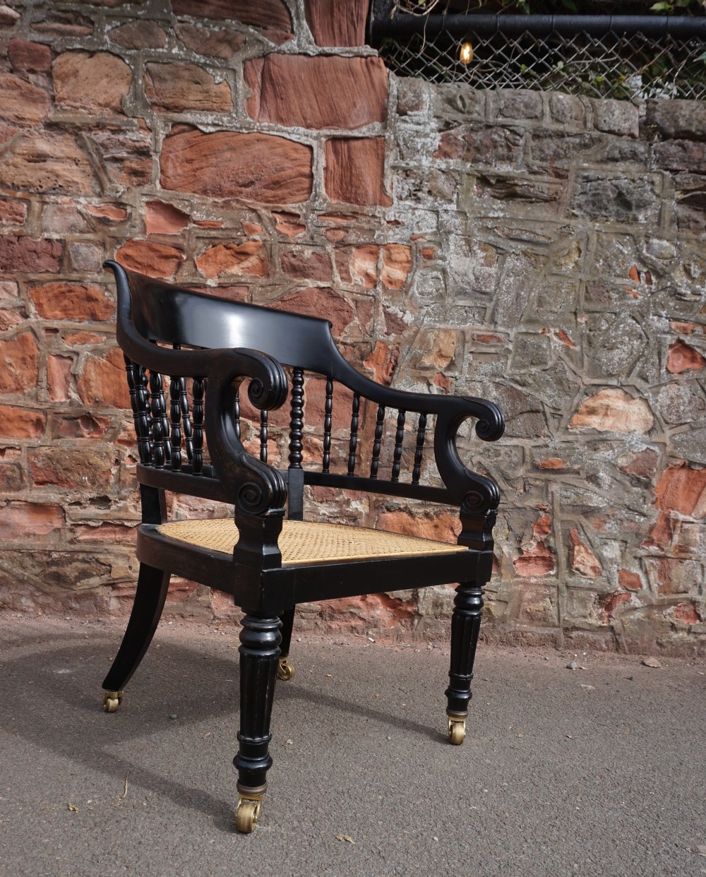 A Scottish George IV ebonised library bergere armchair