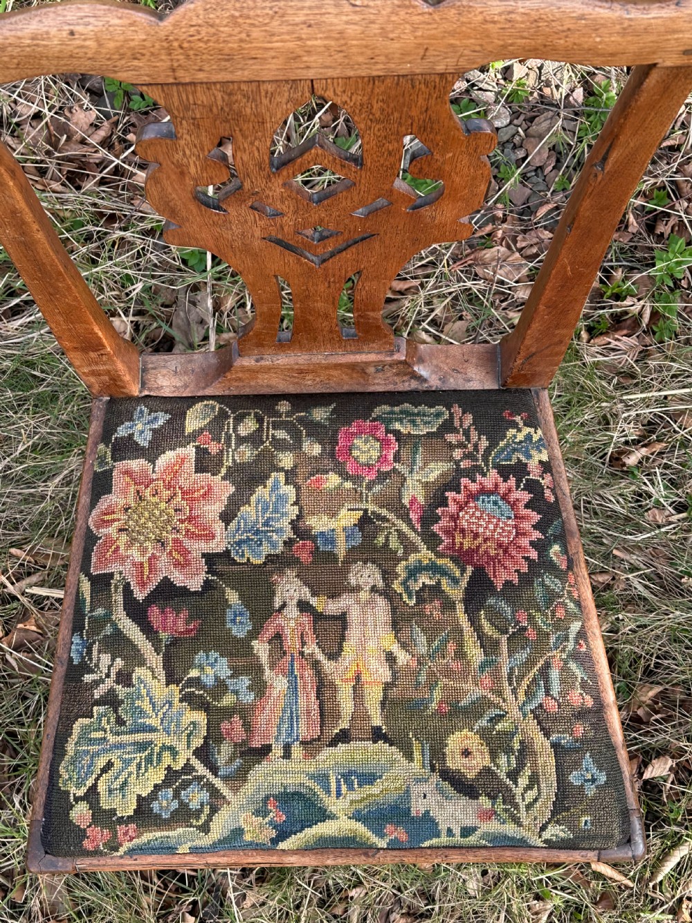 A George III walnut side chair featuring a carved pierced splat back and a floral needlepoint upholstered drop-in seat. View VI
