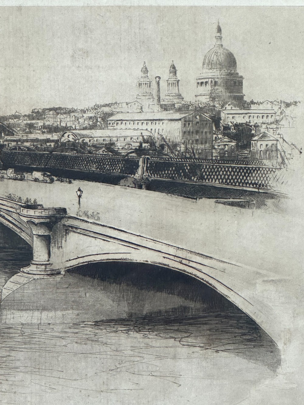 A monochrome drypoint etching depicting Blackfriars Bridge over the River Thames with St Pauls Cathedral visible in the London skyline. View III