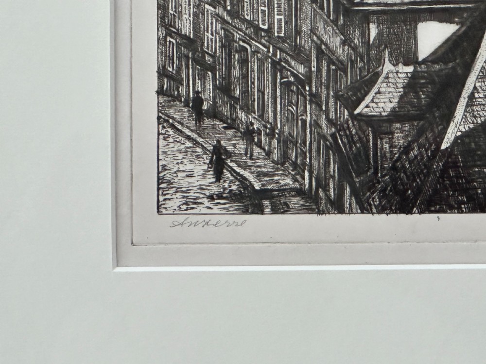 A framed black and white drypoint etching depicting rooftops and a cathedral in Auxerre, displayed within a cream mount and a gold-coloured wooden frame. View II