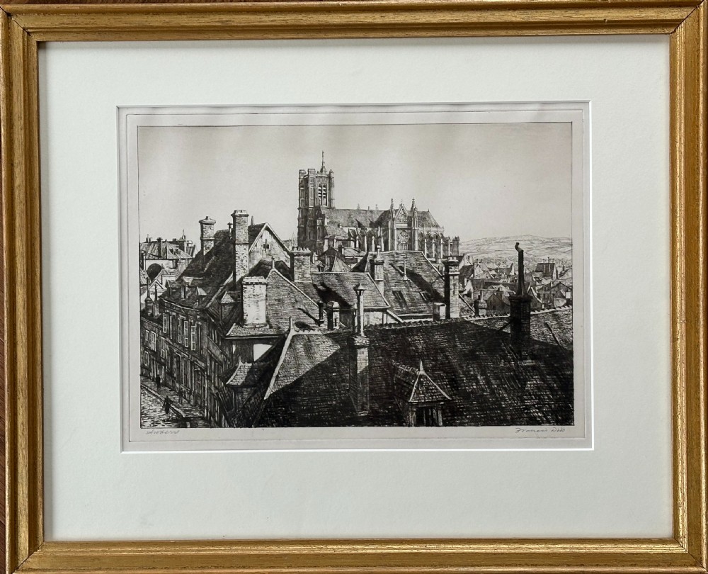 A framed black and white drypoint etching depicting rooftops and a cathedral in Auxerre, displayed within a cream mount and a gold-coloured wooden frame.