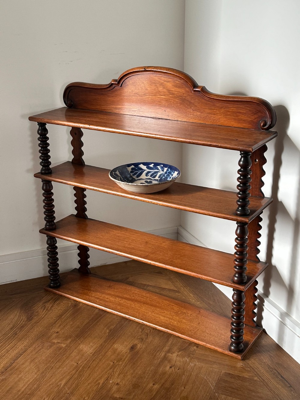A mid-19th century mahogany set of shelves with bobbin supports