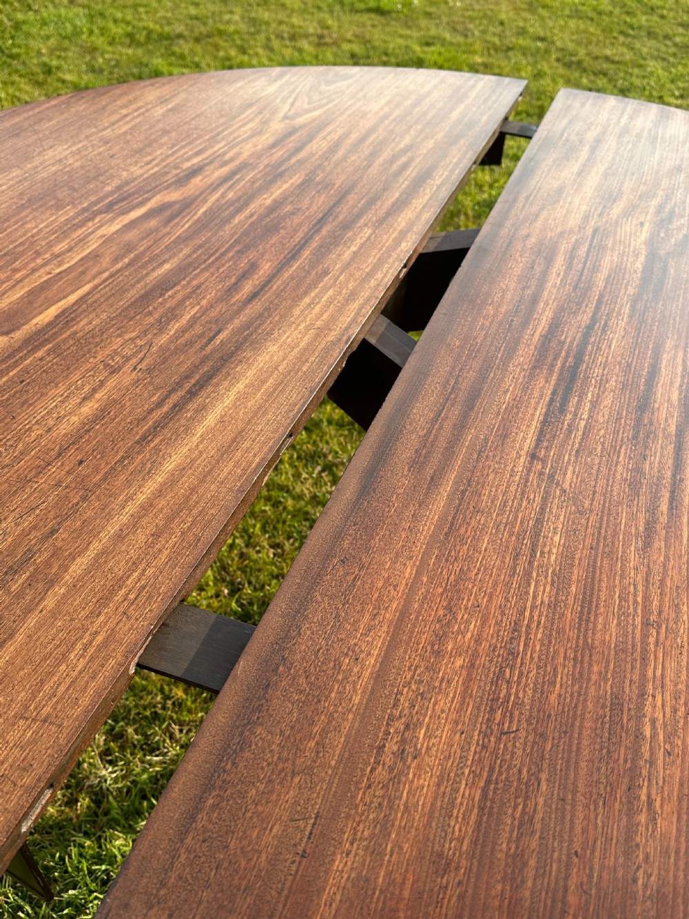 A late 18th-century George III mahogany hunt table featuring two large semi-circular drop leaves and tapered square legs. View V