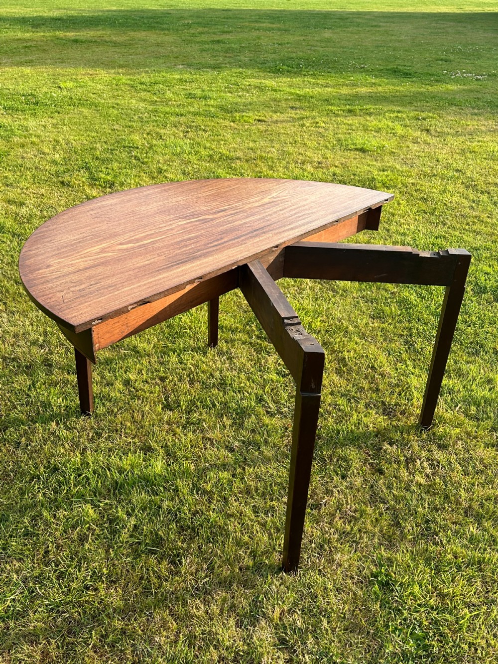 A late 18th-century George III mahogany hunt table featuring two large semi-circular drop leaves and tapered square legs. View IX