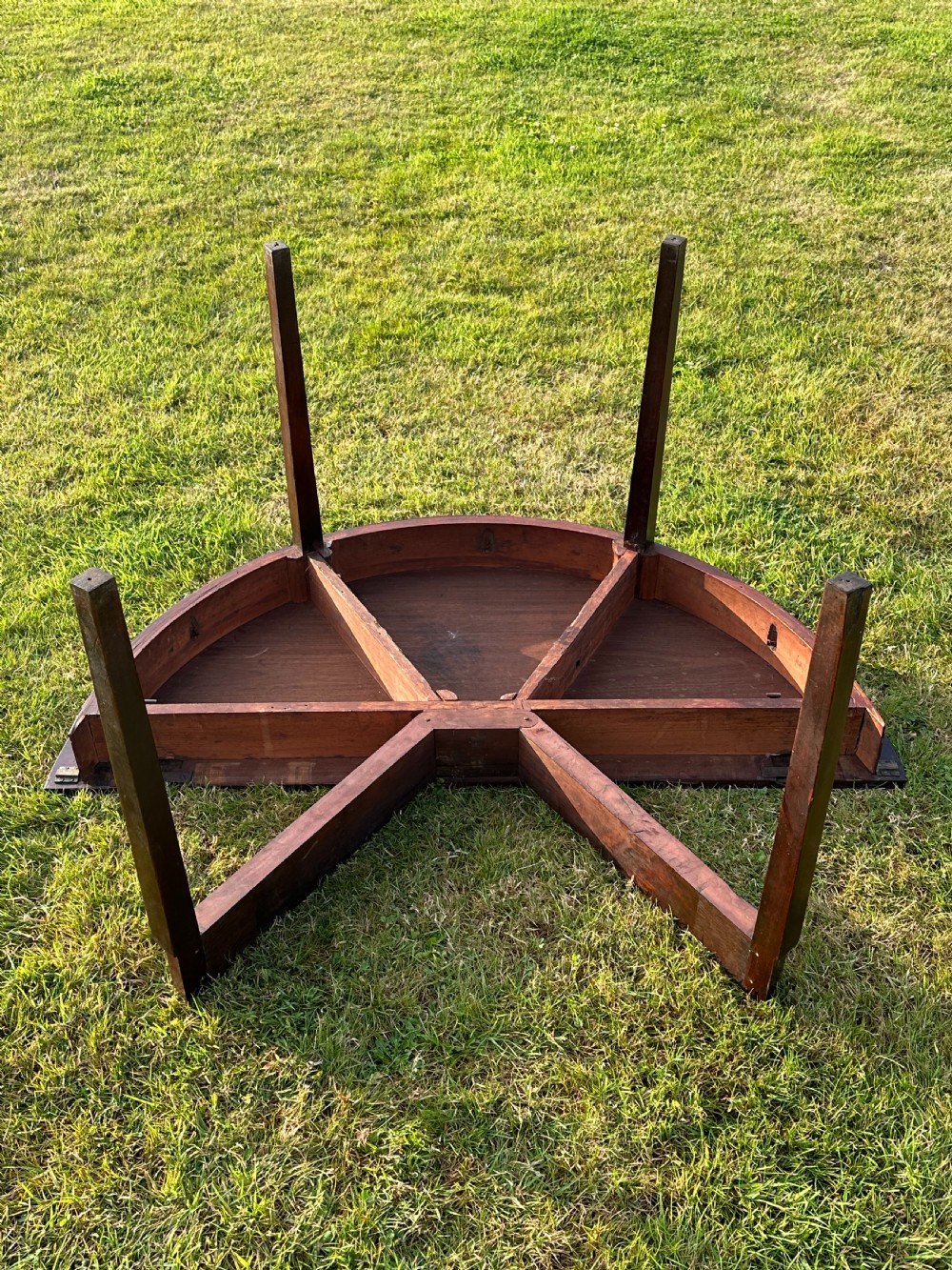 A late 18th-century George III mahogany hunt table featuring two large semi-circular drop leaves and tapered square legs. View X