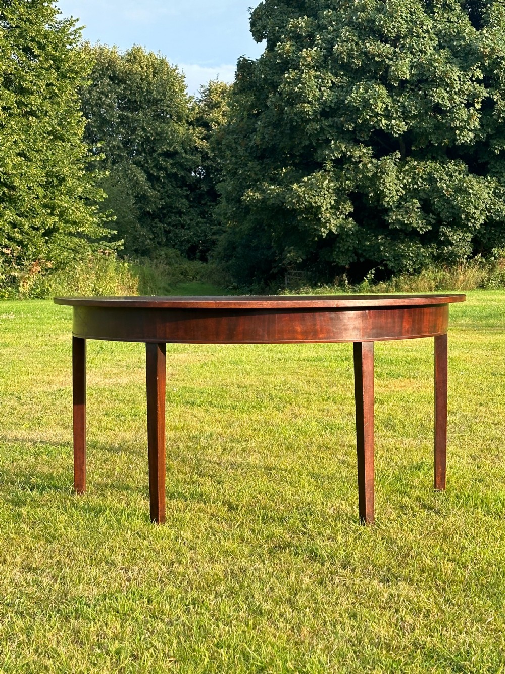 A late 18th-century George III mahogany hunt table featuring two large semi-circular drop leaves and tapered square legs. View XIV