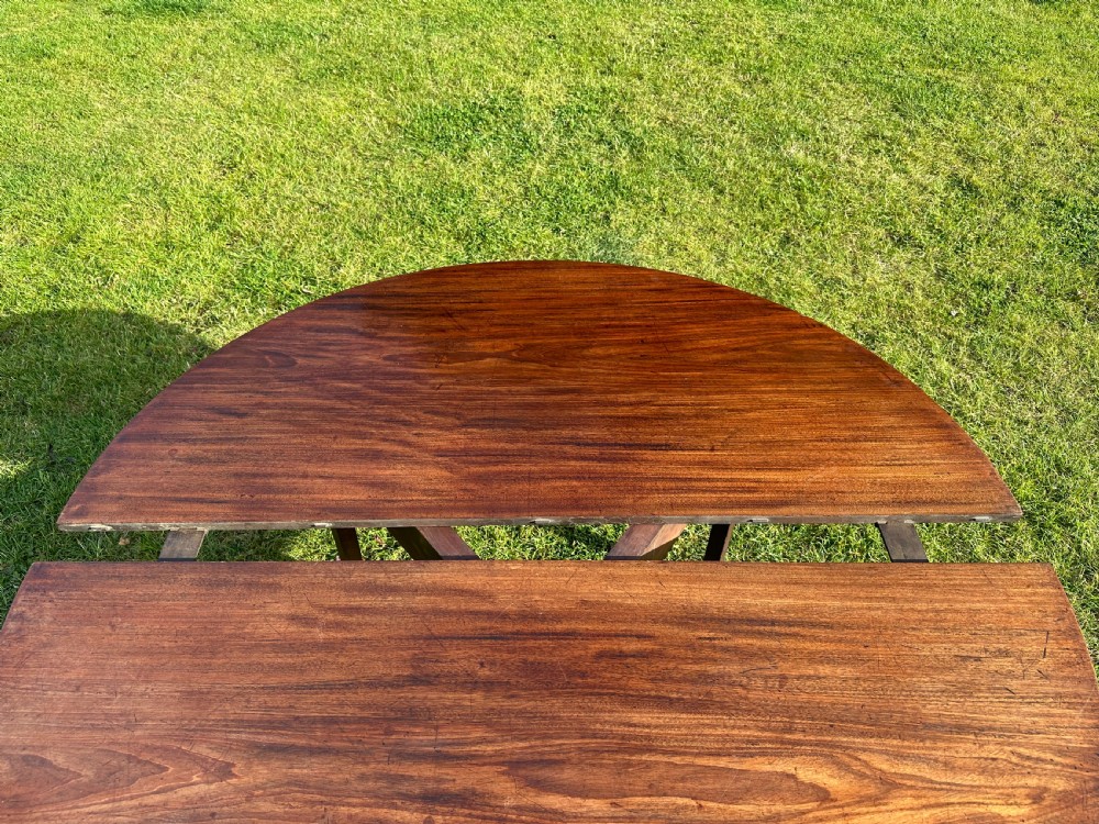 A late 18th-century George III mahogany hunt table featuring two large semi-circular drop leaves and tapered square legs. View XV