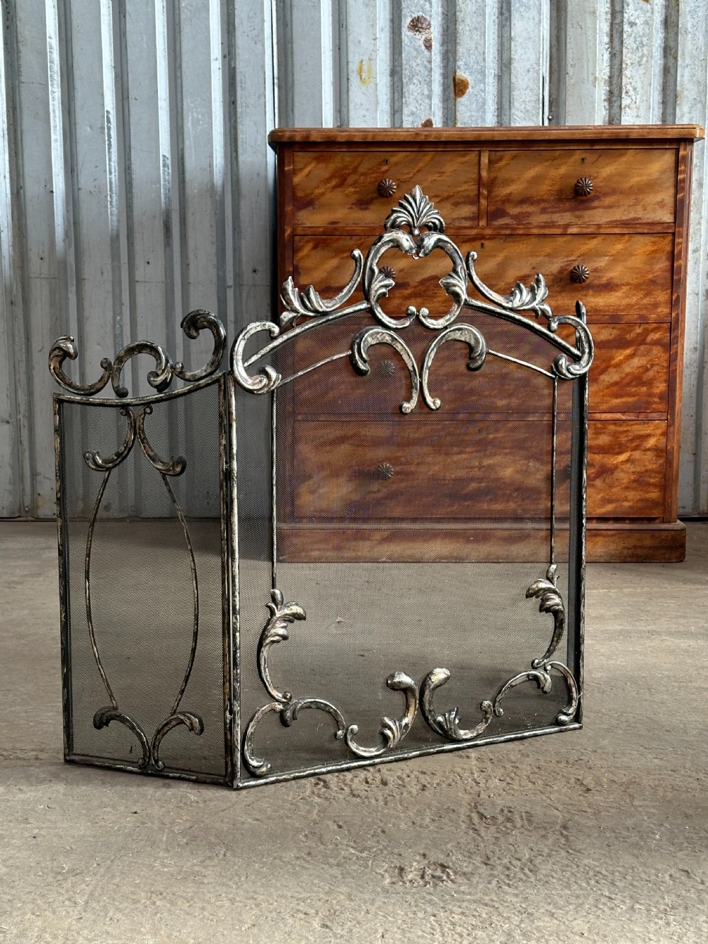 An early 20th century pressed metal fireguard in the rococo taste