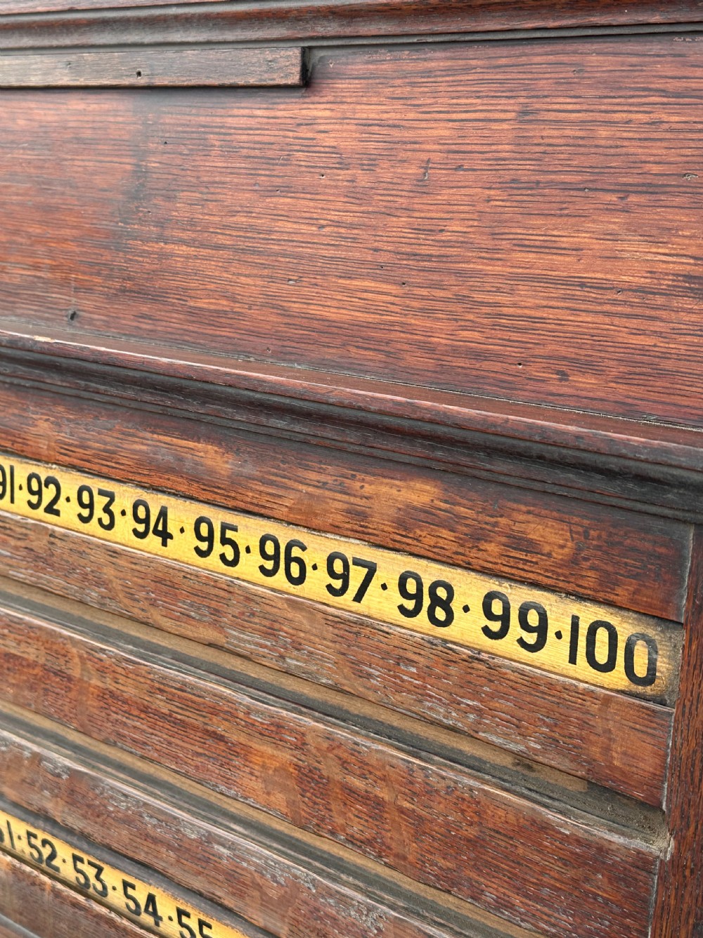 A nineteenth-century dark oak billiard scoreboard featuring numbered sliding brass pointers, moulded architectural cornices, and lower storage compartments. View III