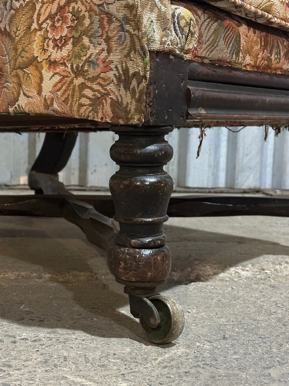 A mid-19th-century English ebonised reclining library armchair with patterned fabric upholstery and turned front legs on brass castors. View VIII