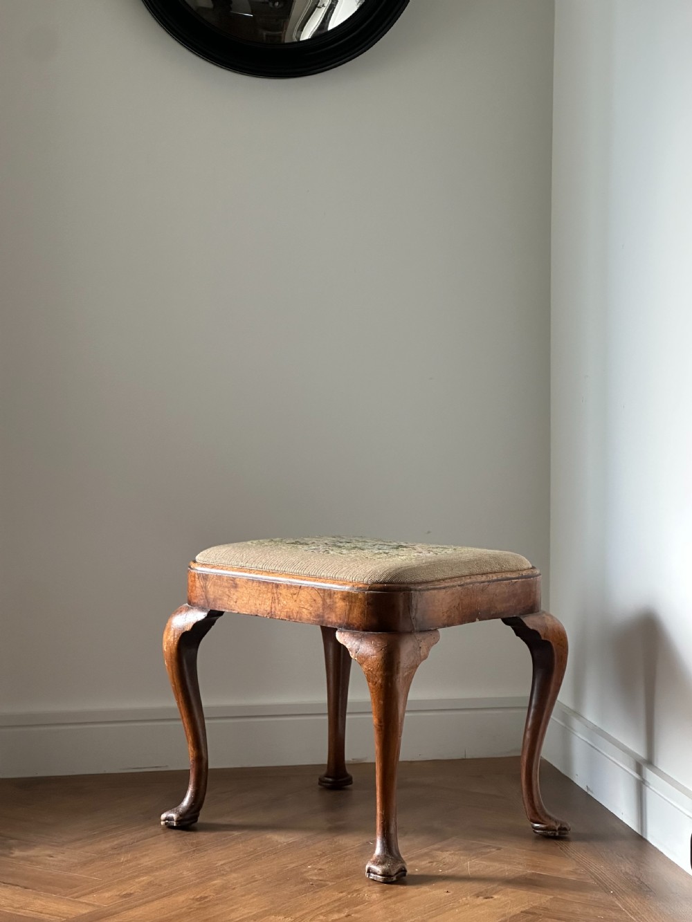 A Queen Anne style walnut stool with drop in seat, first quarter 20th century