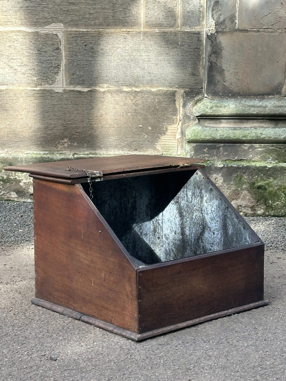 A Scottish George III period oak coal bunker featuring a slanted hinged lid with a dark turned wooden knob and brass strap hinges. View VII