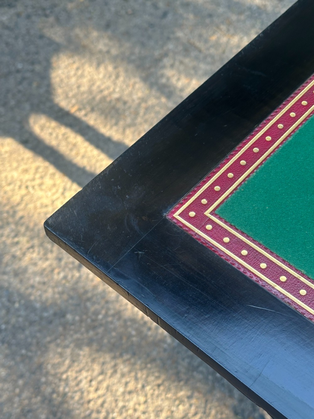 A late Victorian ebonised and parcel gilt card table with a green baize top and turned amboyna columns. View IV