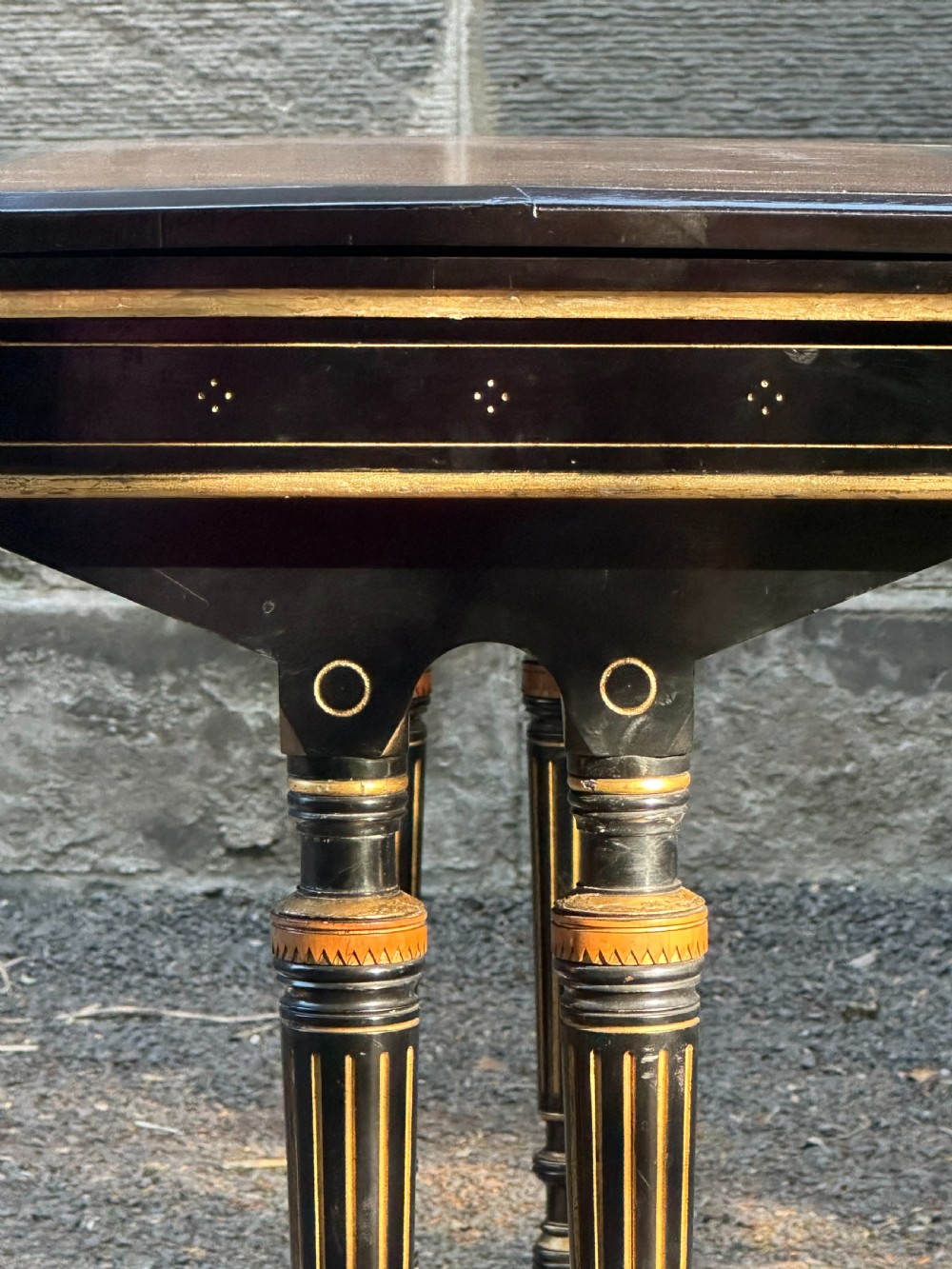 A late Victorian ebonised and parcel gilt card table with a green baize top and turned amboyna columns. View V