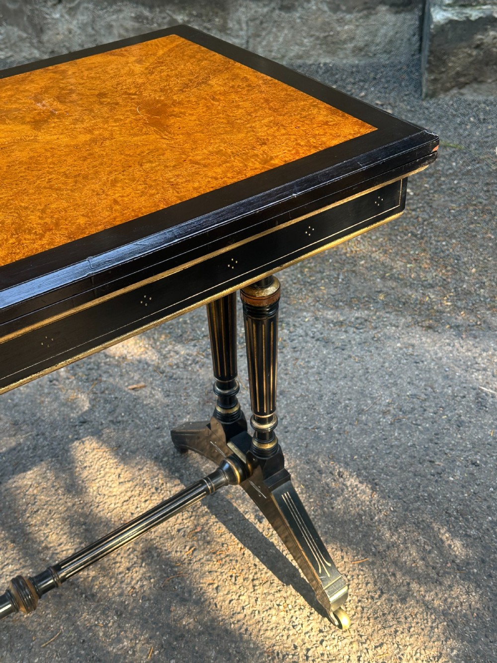 A late Victorian ebonised and parcel gilt card table with a green baize top and turned amboyna columns. View IX