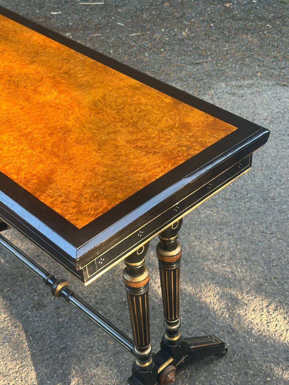 A late Victorian ebonised and parcel gilt card table with a green baize top and turned amboyna columns. View X
