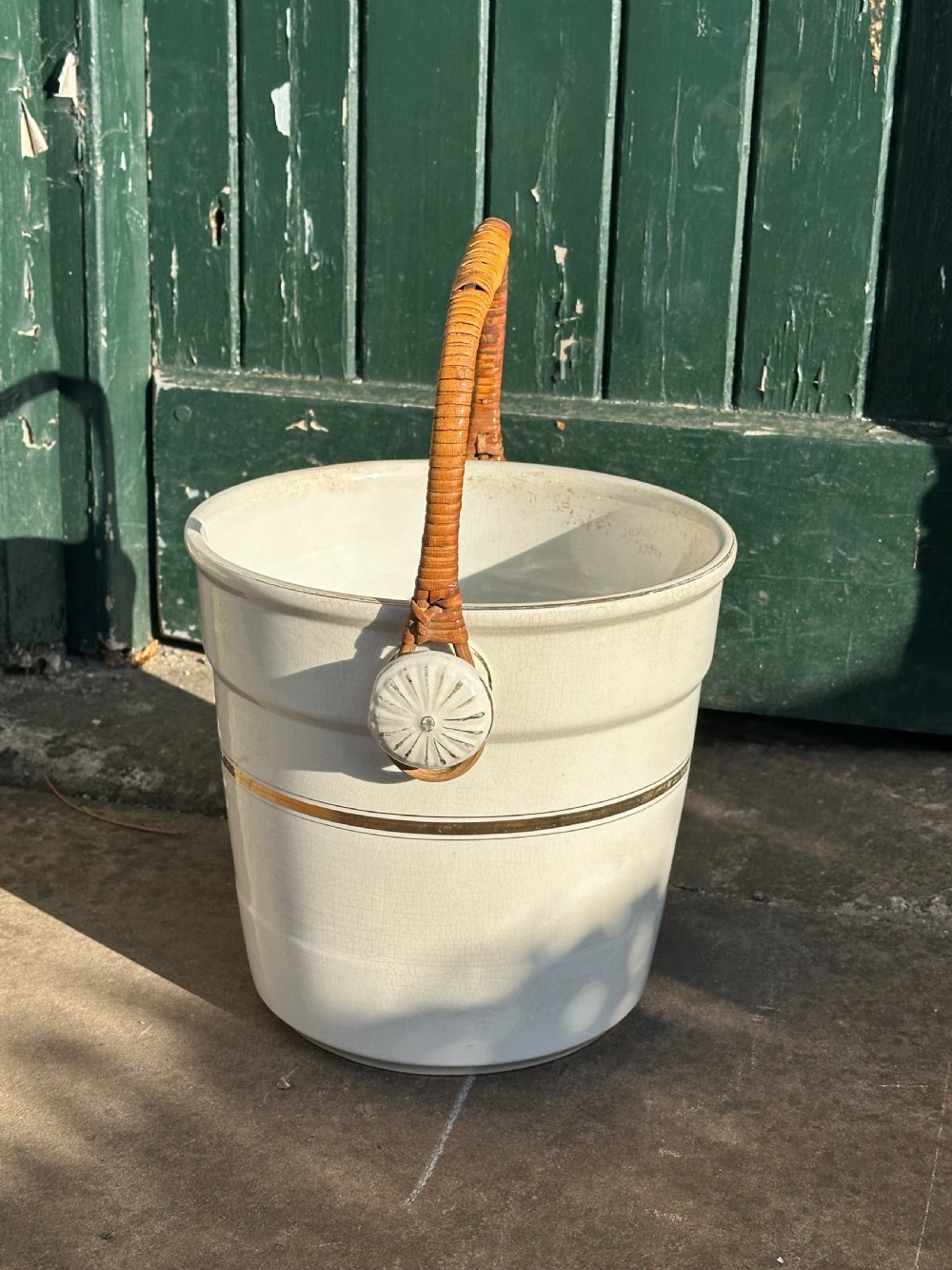 A cream-glazed ceramic bucket featuring a horizontal gilt line and a cane-wrapped overhead swing handle. View IV