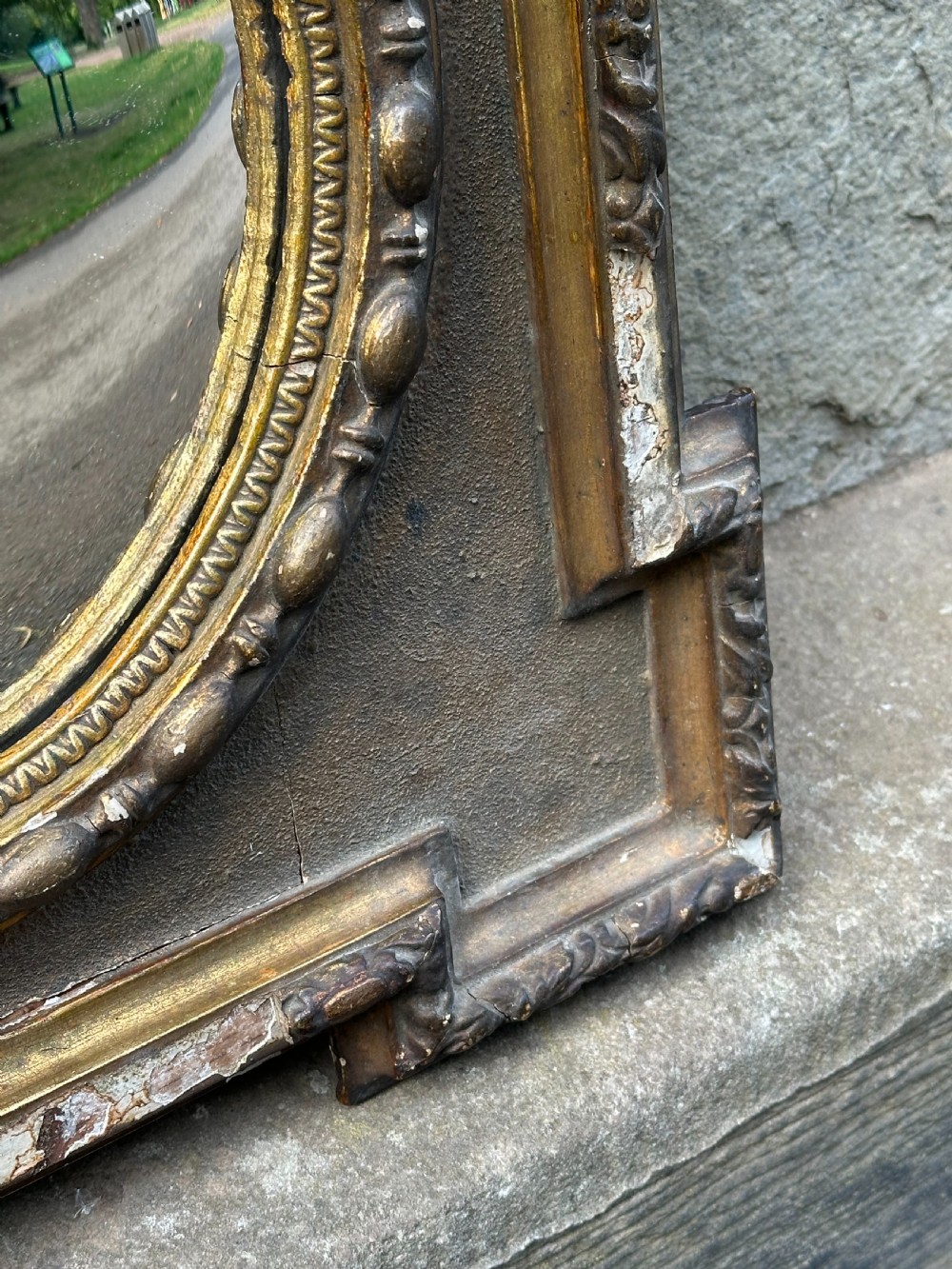 A late 19th-century square dark wood wall mirror featuring stepped architectural outer corners and a central gilt-trimmed circular convex mirror. View II