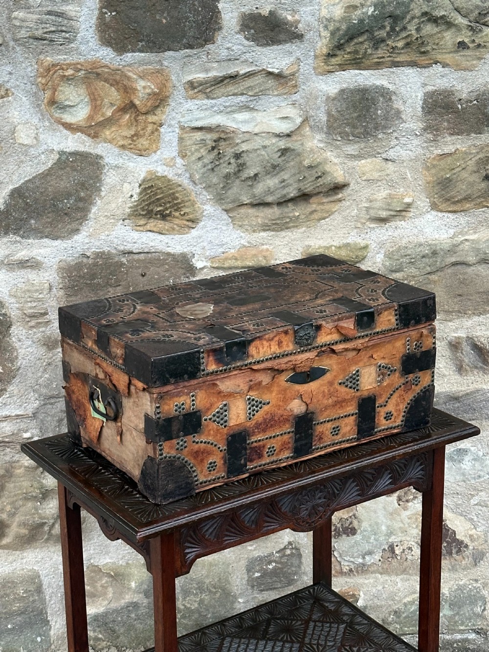 A late George III hide and metal bound travelling trunk featuring brass stud embellishments, iron corner brackets, and carrying handles. View V