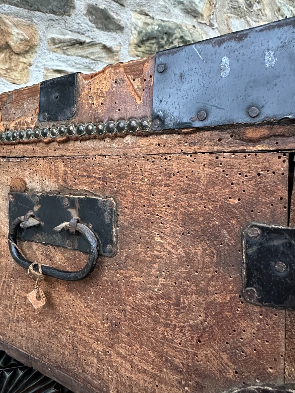 A late George III hide and metal bound travelling trunk featuring brass stud embellishments, iron corner brackets, and carrying handles. View XI
