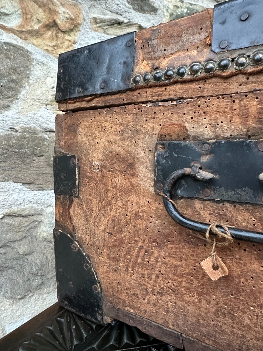 A late George III hide and metal bound travelling trunk featuring brass stud embellishments, iron corner brackets, and carrying handles. View XII