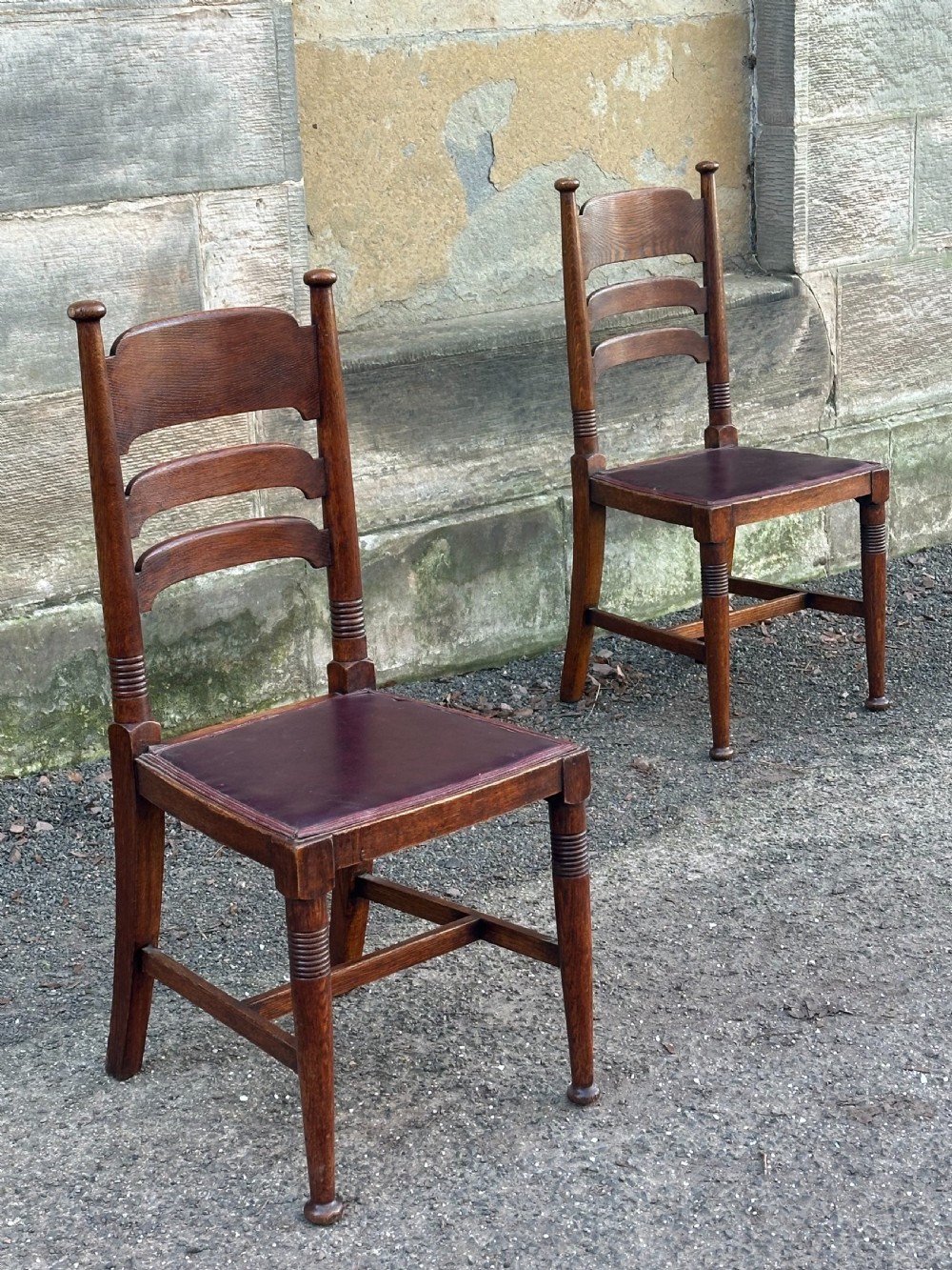 A pair of English Arts and Crafts oak side chairs by William Birch Ltd. c.1900