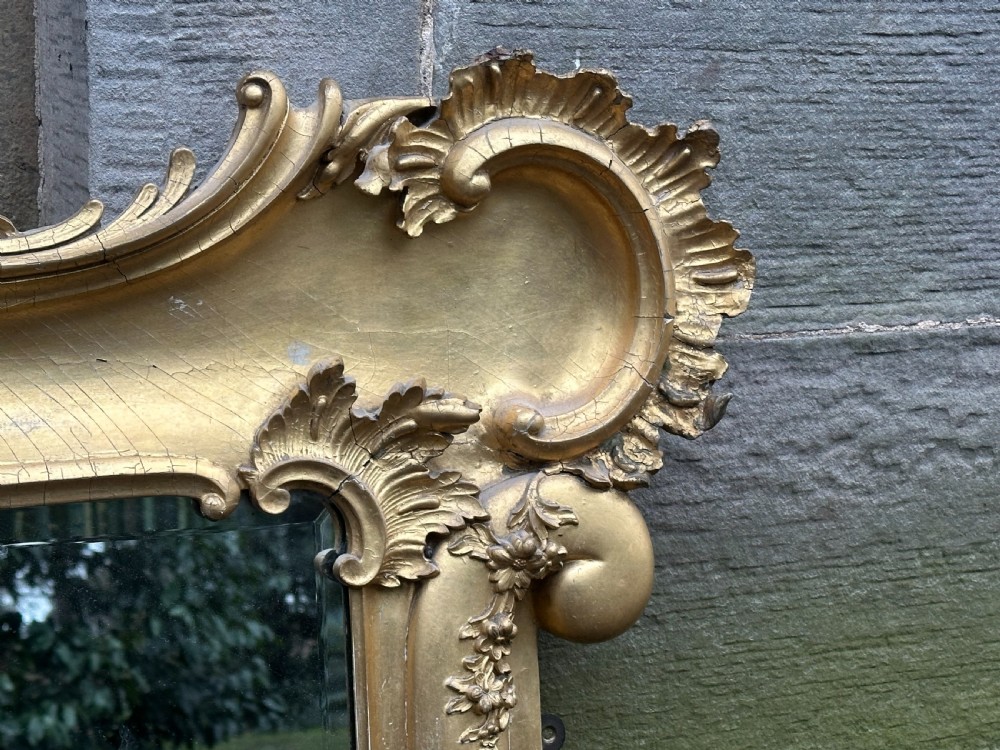 A wide 19th-century gilded gesso overmantel mirror featuring a three-panel glass design and ornate acanthus leaf cresting. View II