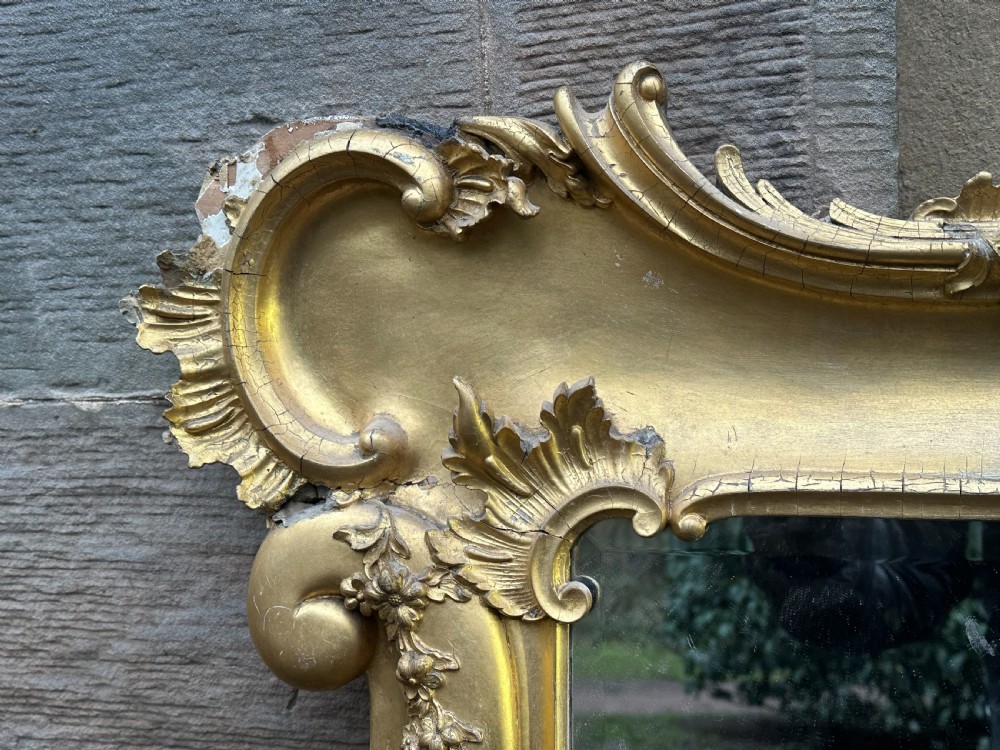 A wide 19th-century gilded gesso overmantel mirror featuring a three-panel glass design and ornate acanthus leaf cresting. View III
