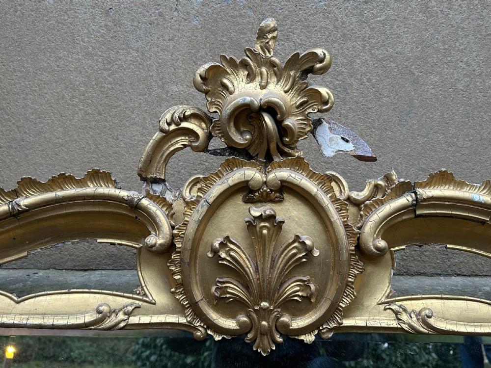 A wide 19th-century gilded gesso overmantel mirror featuring a three-panel glass design and ornate acanthus leaf cresting. View IV