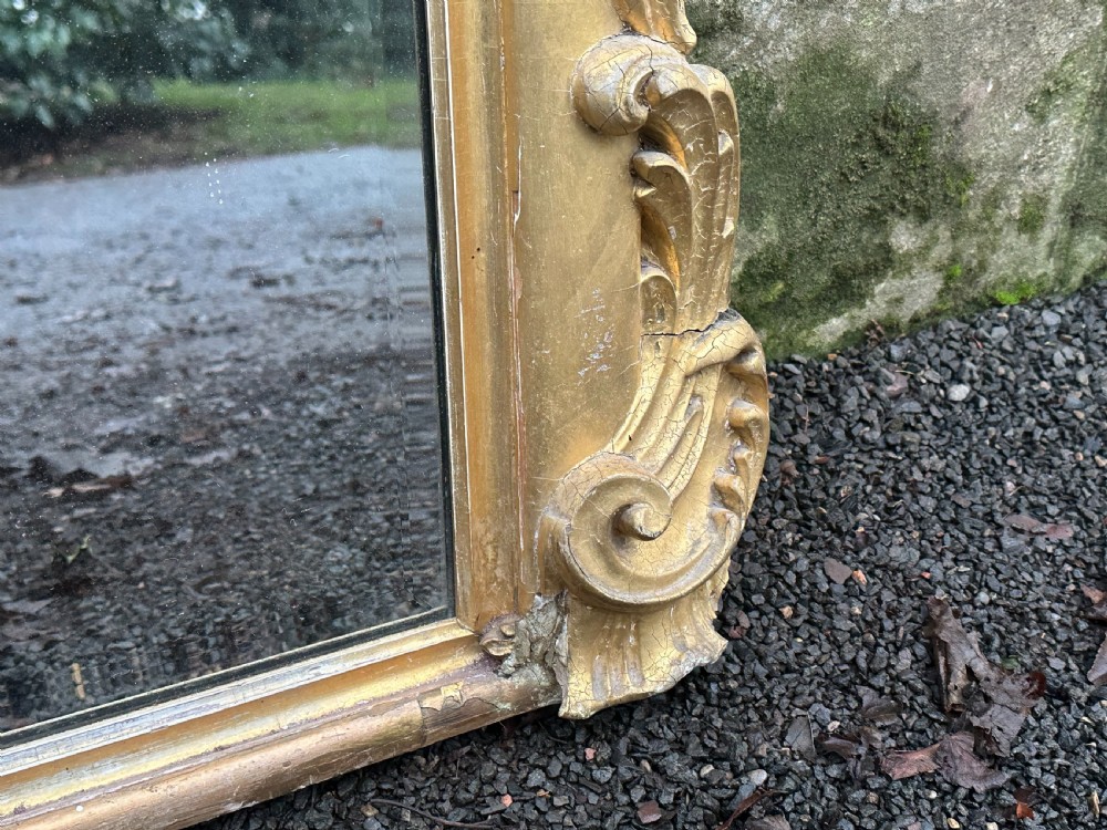 A wide 19th-century gilded gesso overmantel mirror featuring a three-panel glass design and ornate acanthus leaf cresting. View VI