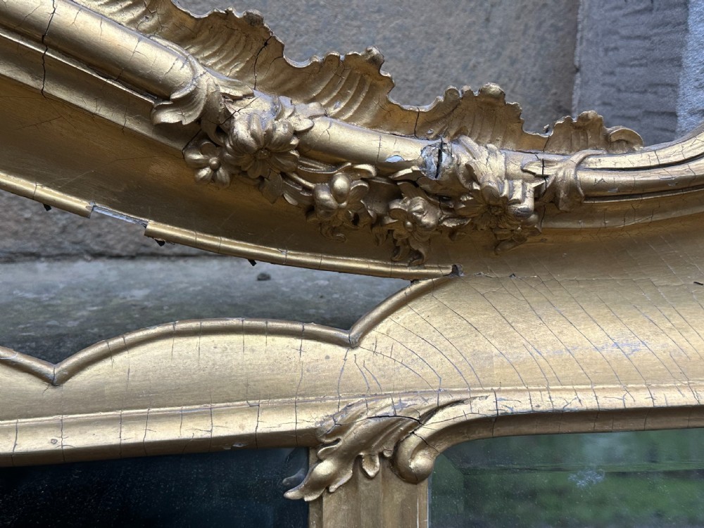 A wide 19th-century gilded gesso overmantel mirror featuring a three-panel glass design and ornate acanthus leaf cresting. View VII