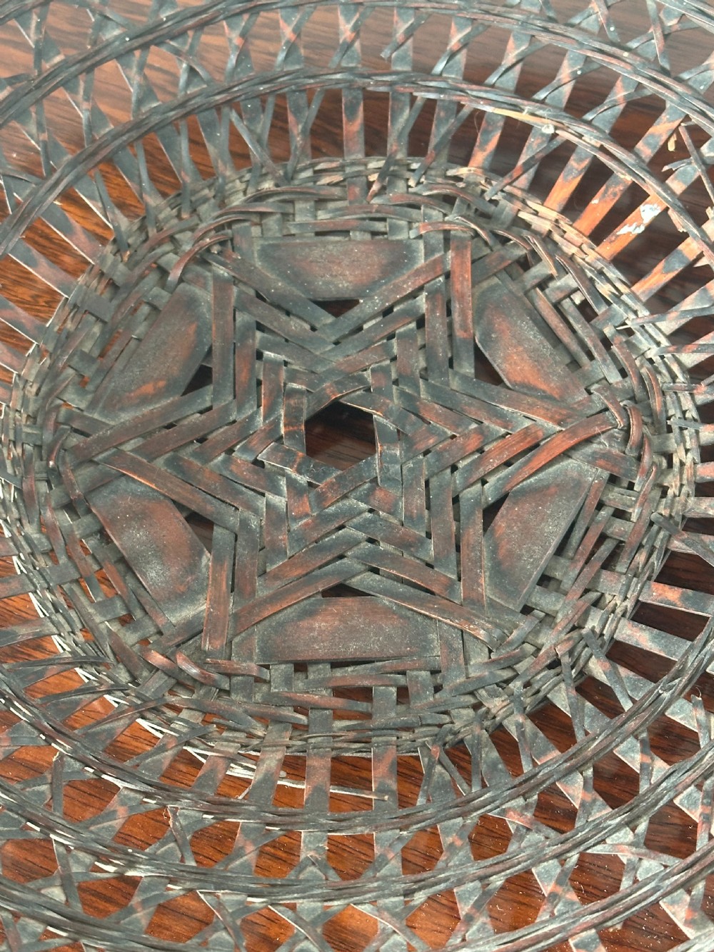 A shallow dark brown woven bamboo Ikebana flower basket featuring an organic gnarled natural rootwood overhead handle. View VIII