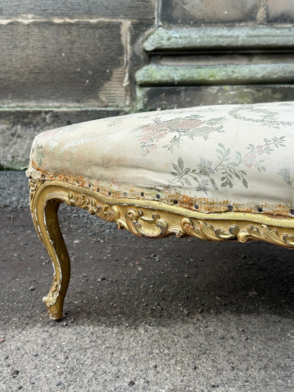 A 19th-century French giltwood centre stool featuring carved Rococo scrollwork, cabriole legs, and floral upholstered seating. View XI