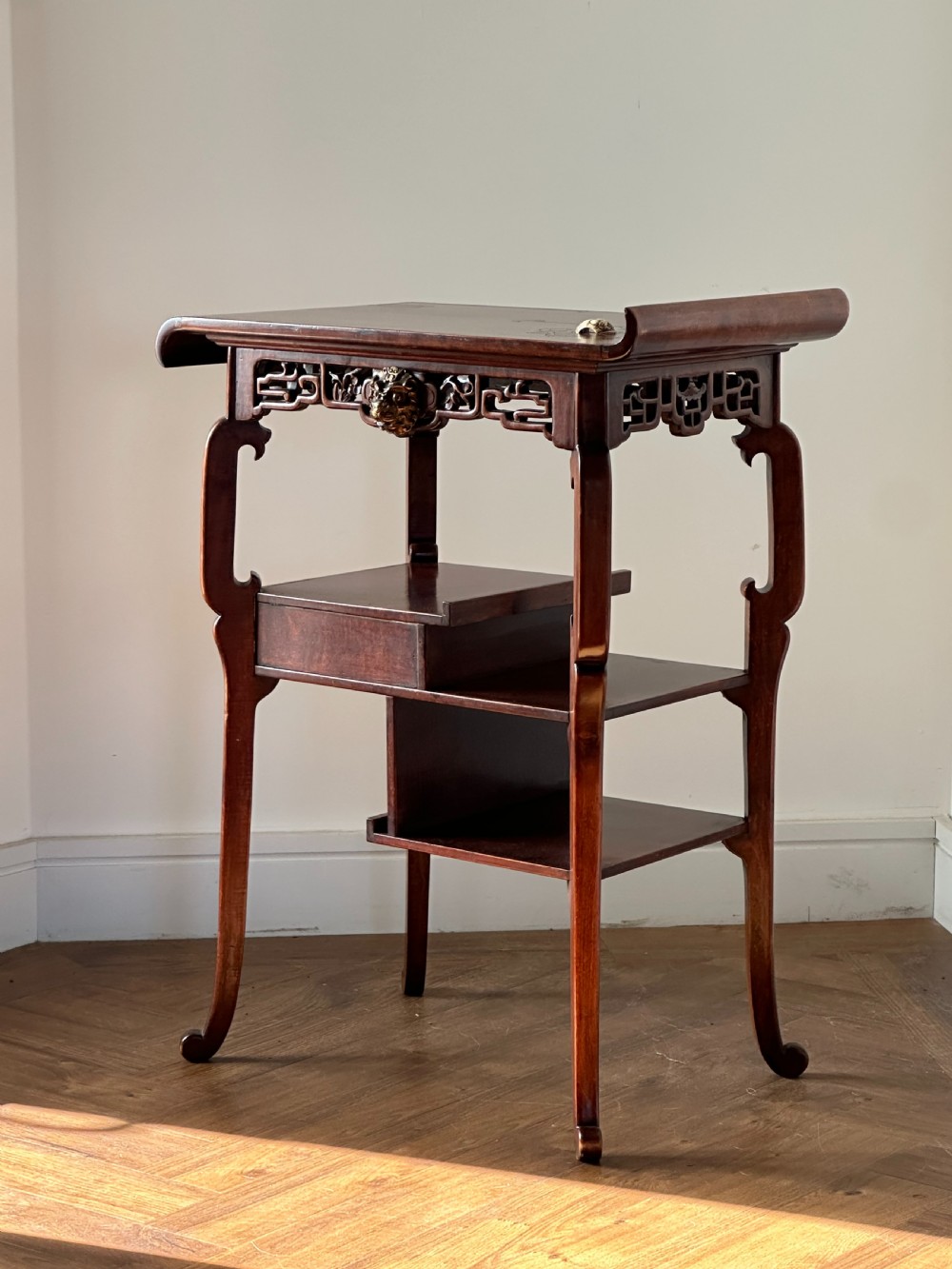 A late 19th-century French Japonisme side table featuring a curved pagoda top, open asymmetrical shelves, pierced wood carving, and a gilt-bronze motif. View V