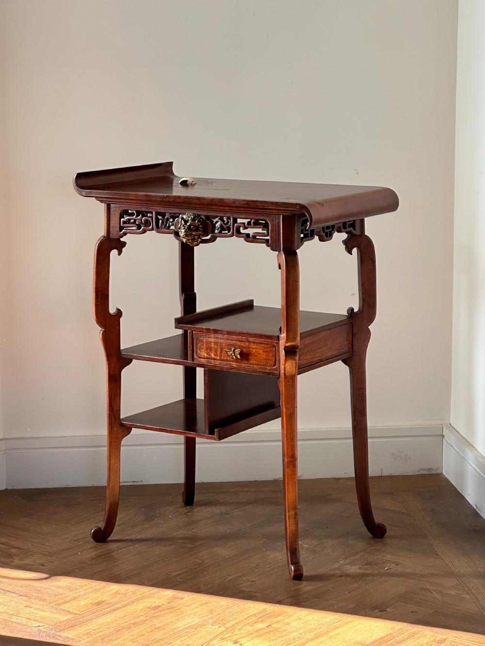 A late 19th-century French Japonisme side table featuring a curved pagoda top, open asymmetrical shelves, pierced wood carving, and a gilt-bronze motif. View X