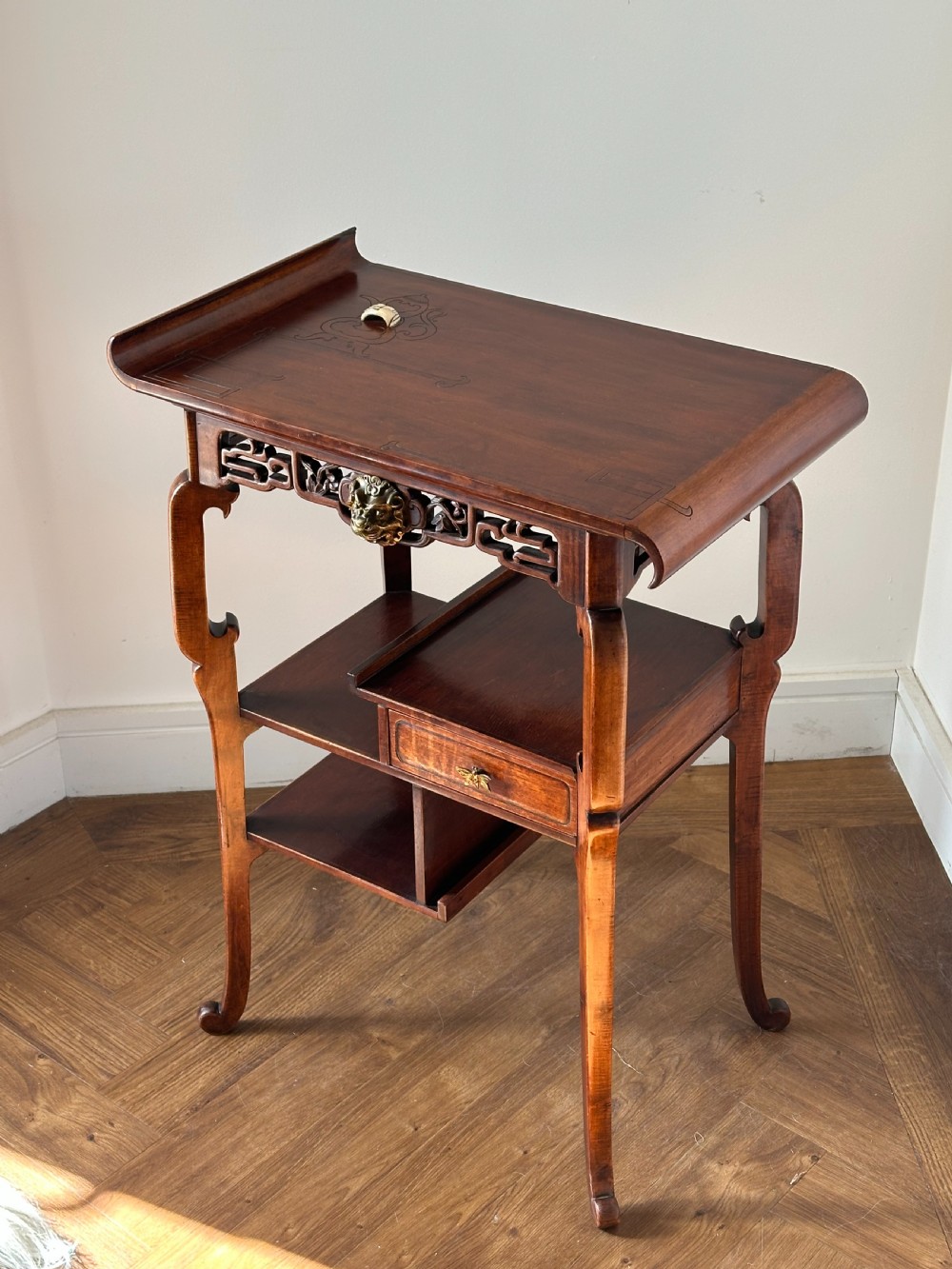 A late 19th-century French Japonisme side table featuring a curved pagoda top, open asymmetrical shelves, pierced wood carving, and a gilt-bronze motif. View XI