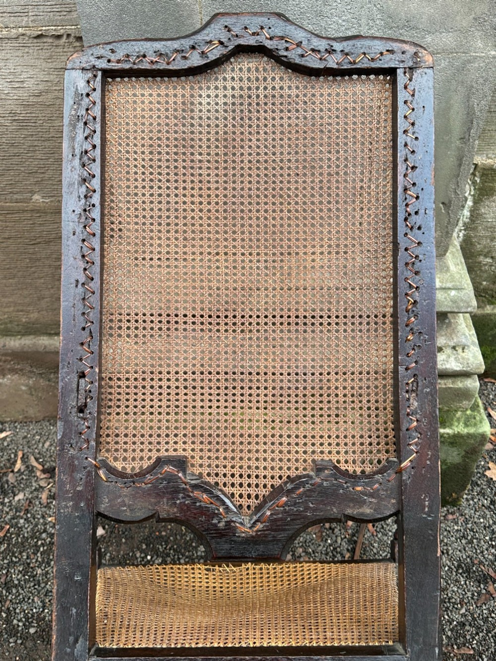 A dark painted walnut open armchair featuring a high woven cane back panel, scrolled arms, a cane seat, and bulbous turned stretchers. View VI