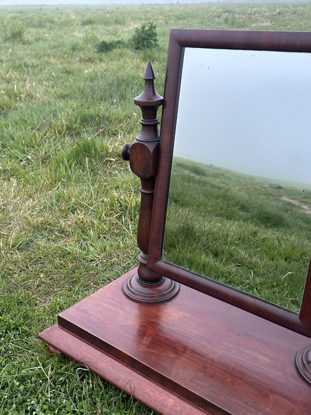 A mid-19th century mahogany dressing mirror featuring turned side supports, finials, and a moulded rectangular plinth base. View VI
