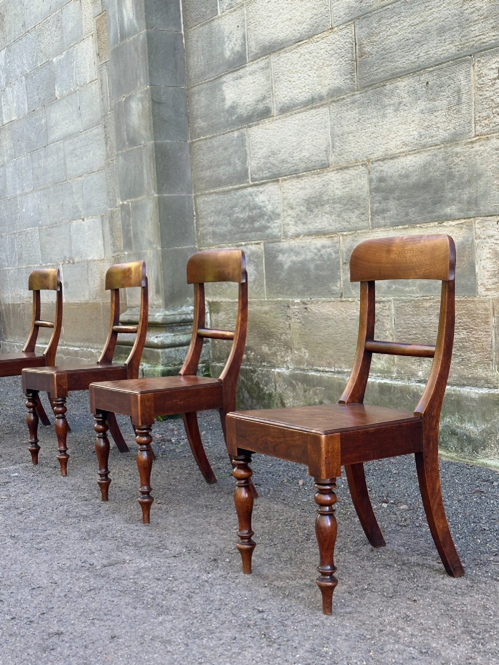 A set of four Victorian birch side chairs featuring curved top rails, turned front legs, and solid timber seats.