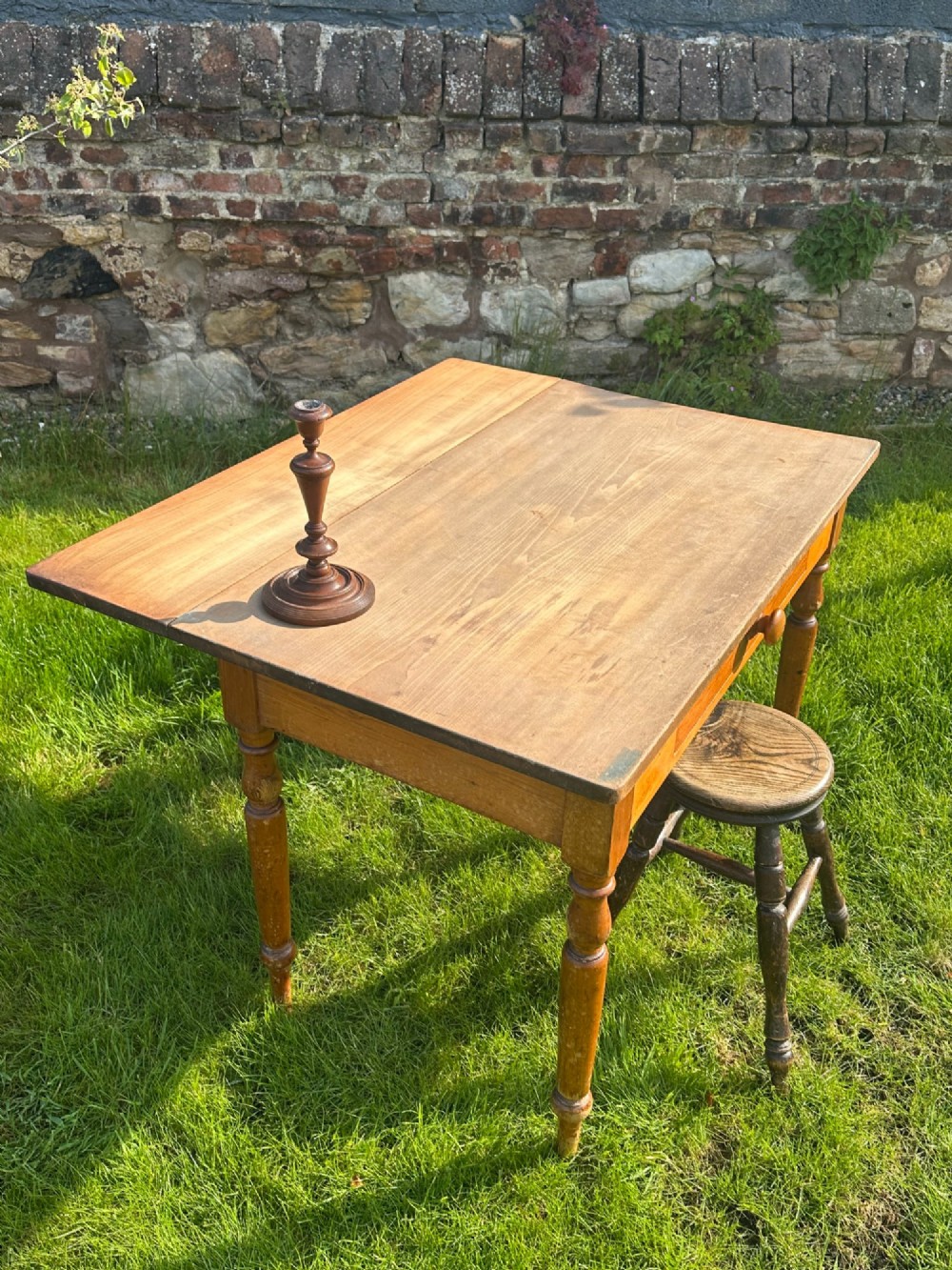 A 19th-century pine kitchen preparation table featuring turned legs, a single frieze drawer with a wooden knob, and a drop-leaf extension. View XII