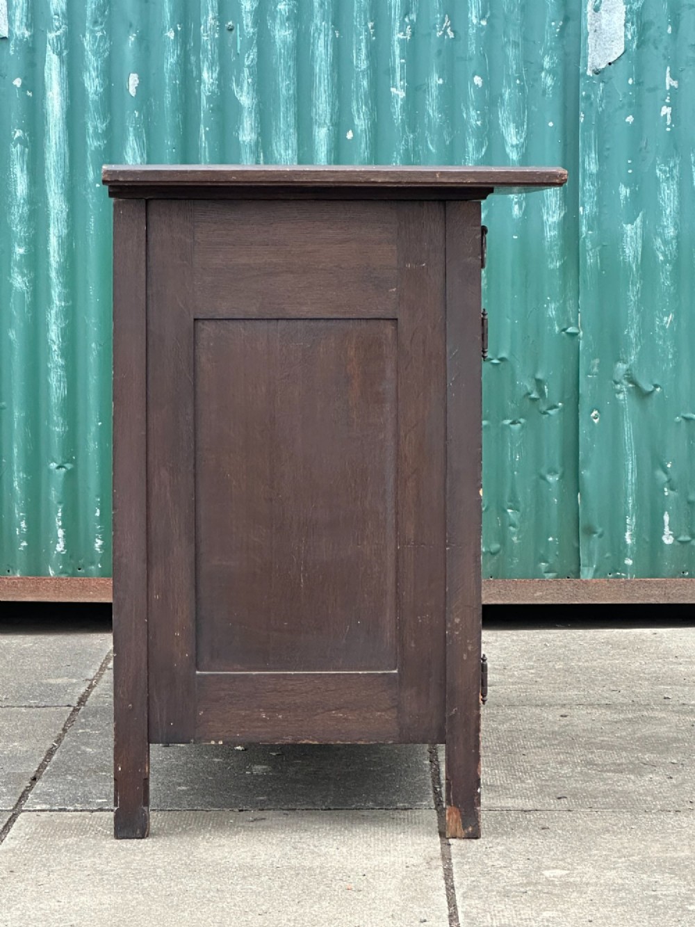 A dark oak Arts and Crafts side cabinet with two upper drawers, lattice glazed double doors, and decorative brass mounts. View VI