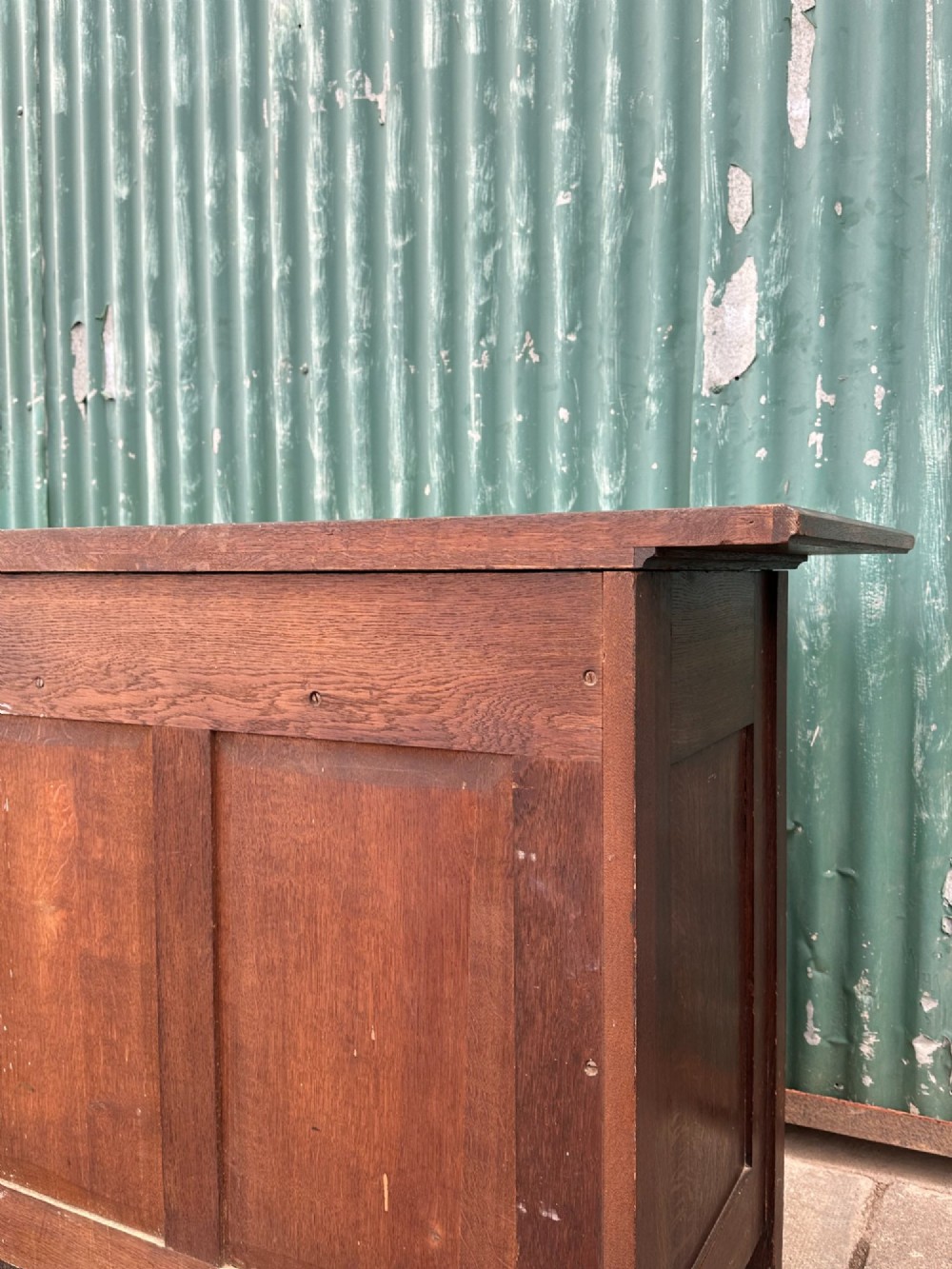 A dark oak Arts and Crafts side cabinet with two upper drawers, lattice glazed double doors, and decorative brass mounts. View VII