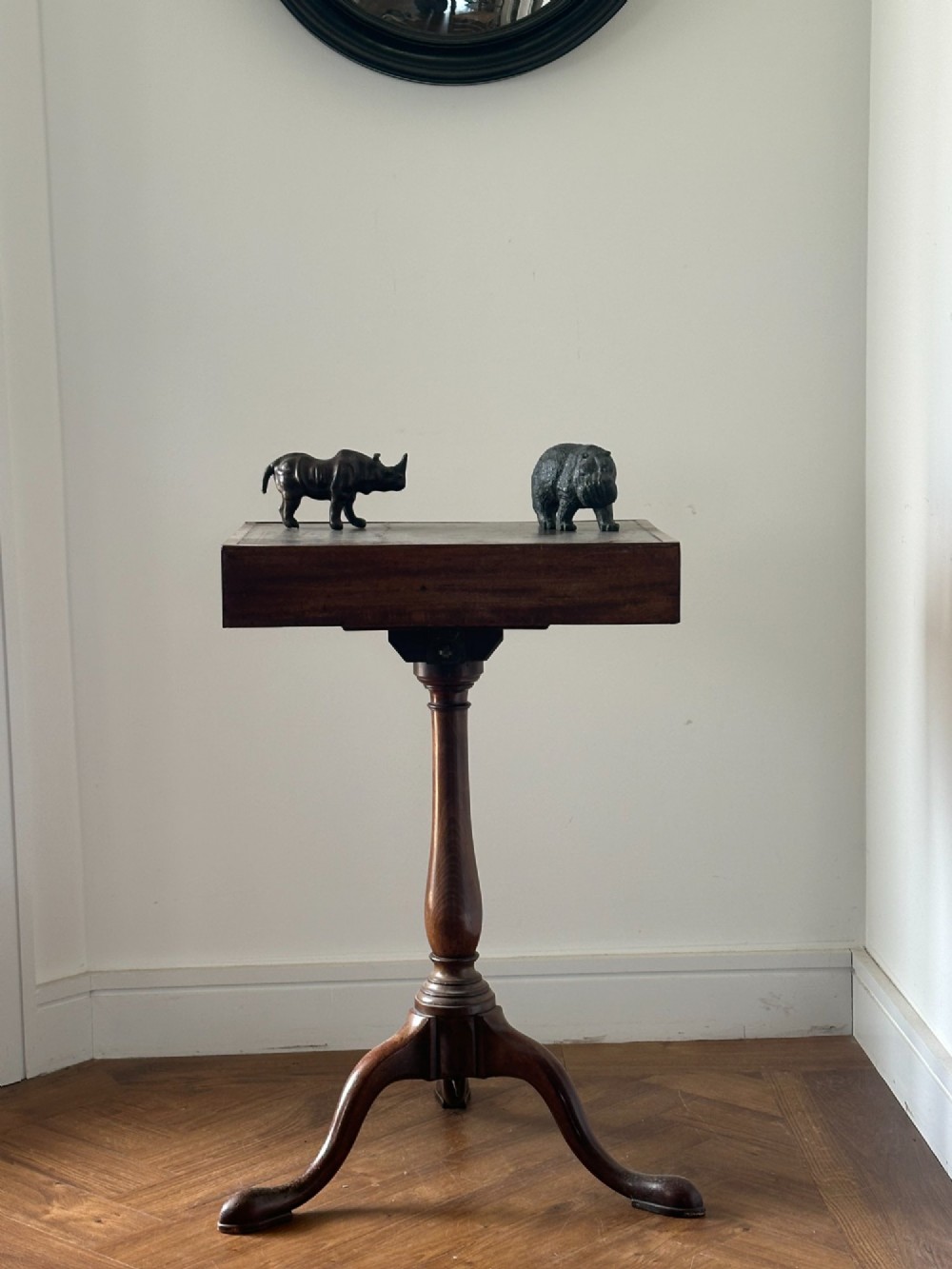 A small moulded dark brown leather rhinoceros desk ornament with textured hide detailing and hand-stitched seams standing on a wooden surface. View III