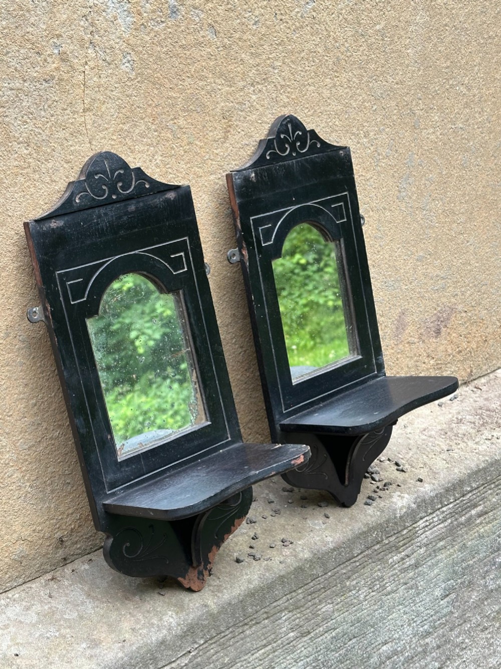 A pair of late 19th-century black ebonised wooden wall girandoles with arched mirror plates, incised scroll detailing, and integrated shelves. View III