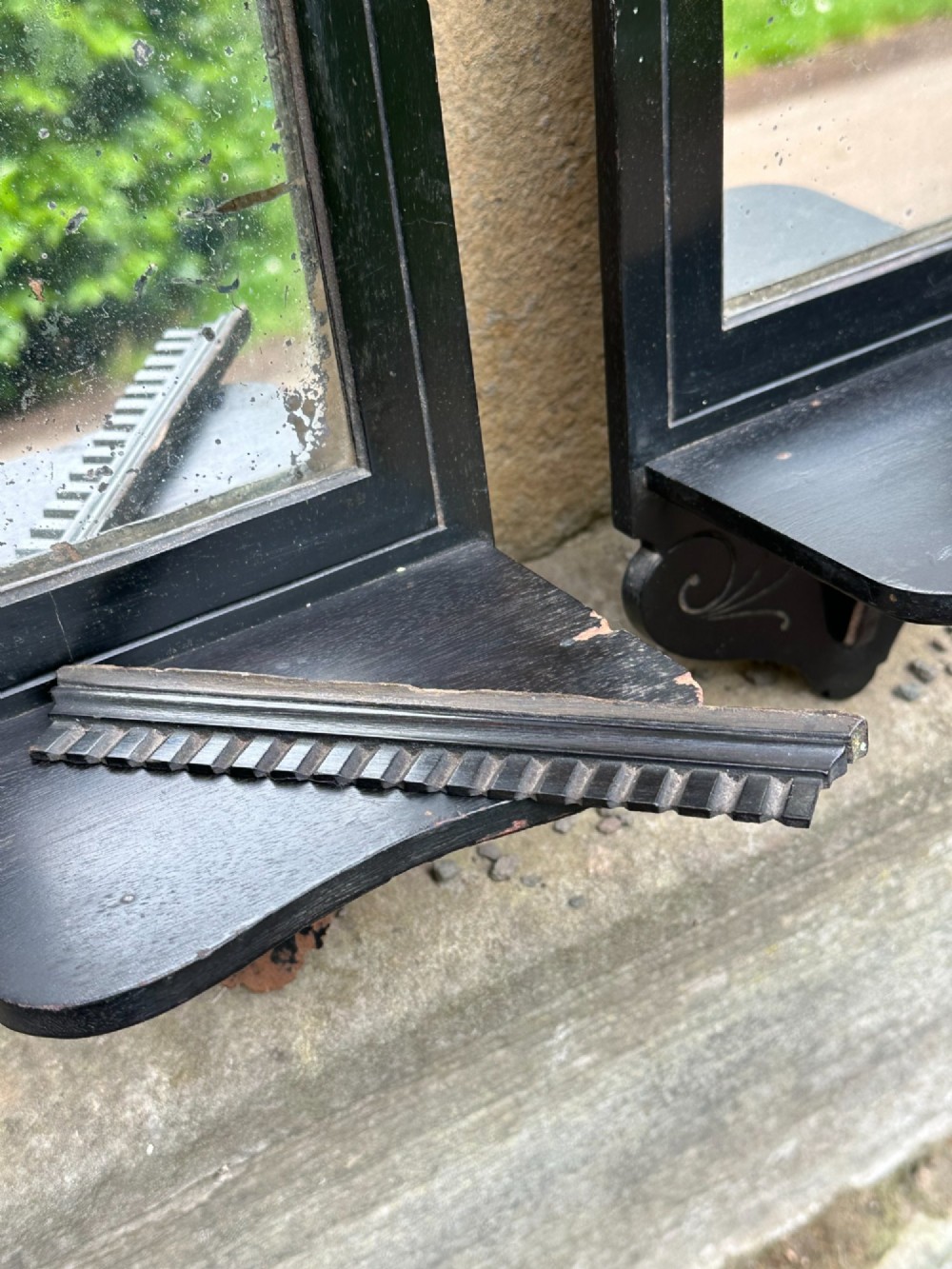 A pair of late 19th-century black ebonised wooden wall girandoles with arched mirror plates, incised scroll detailing, and integrated shelves. View VI