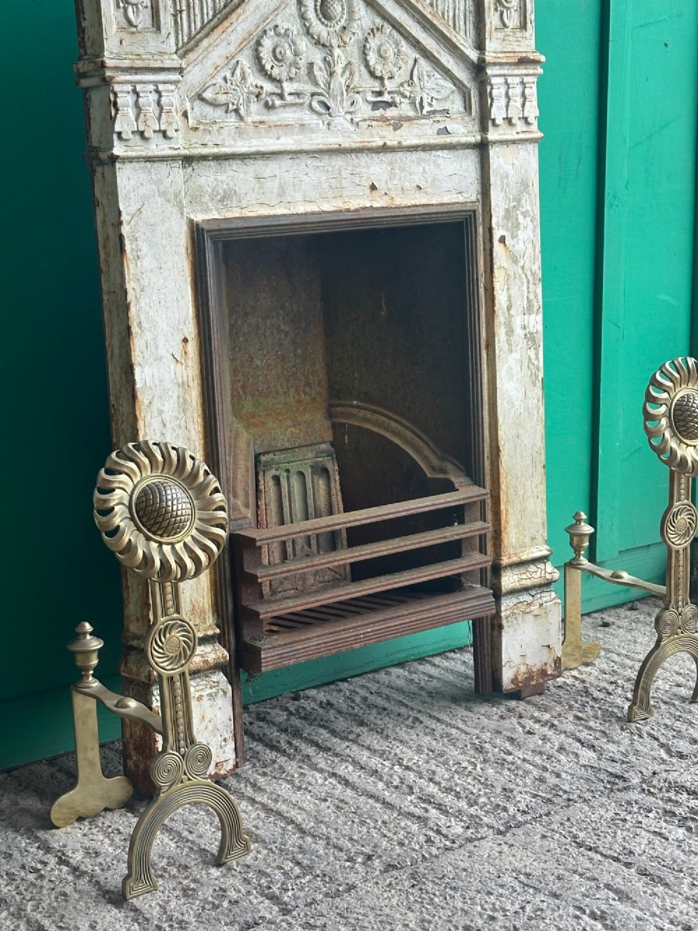 A pair of late Victorian cast brass andirons featuring stylised sunflower tops and geometric scroll detailing. View III