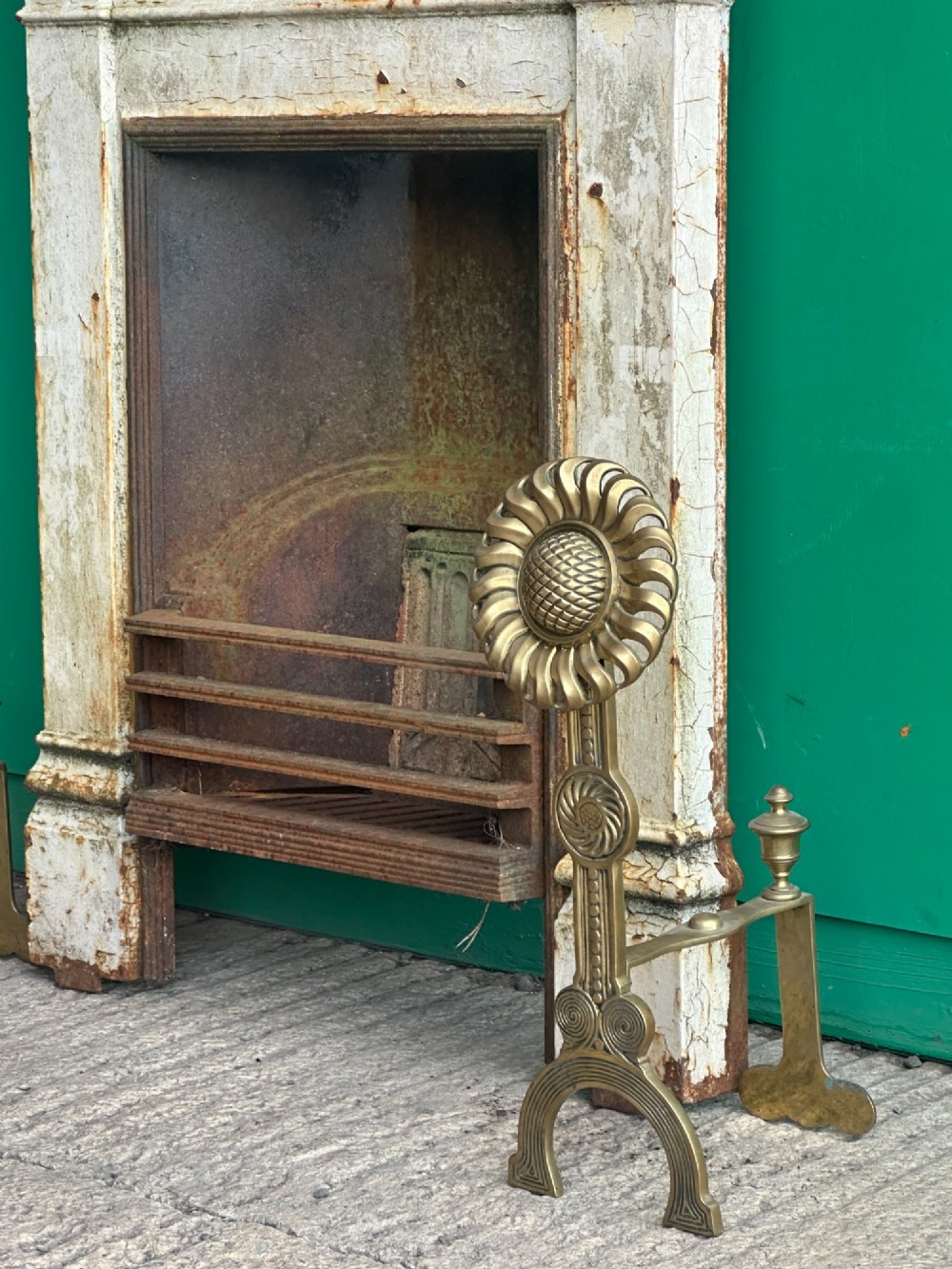 A pair of late Victorian cast brass andirons featuring stylised sunflower tops and geometric scroll detailing. View IV