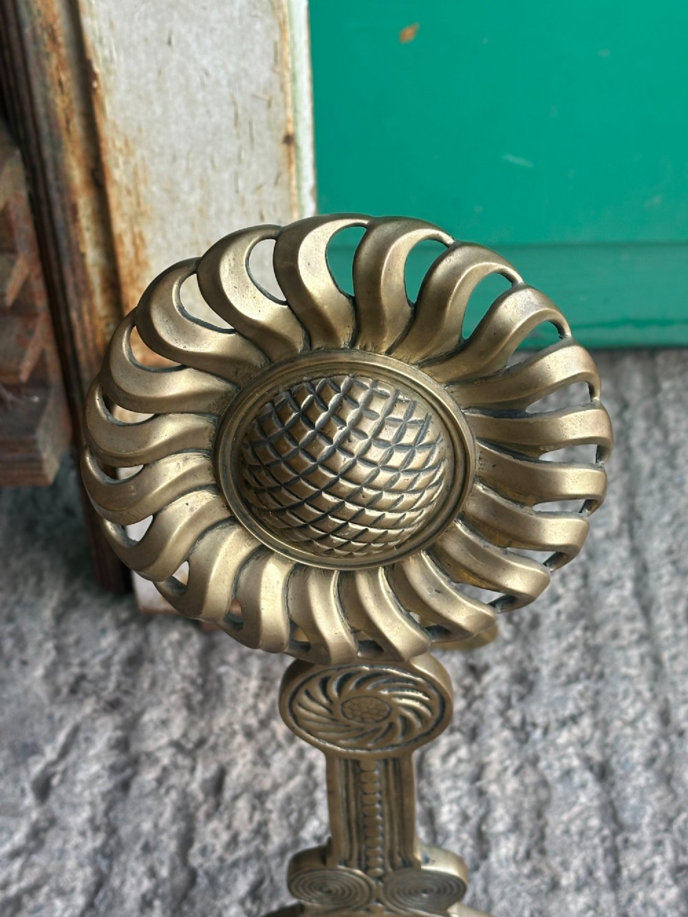 A pair of late Victorian cast brass andirons featuring stylised sunflower tops and geometric scroll detailing. View VII