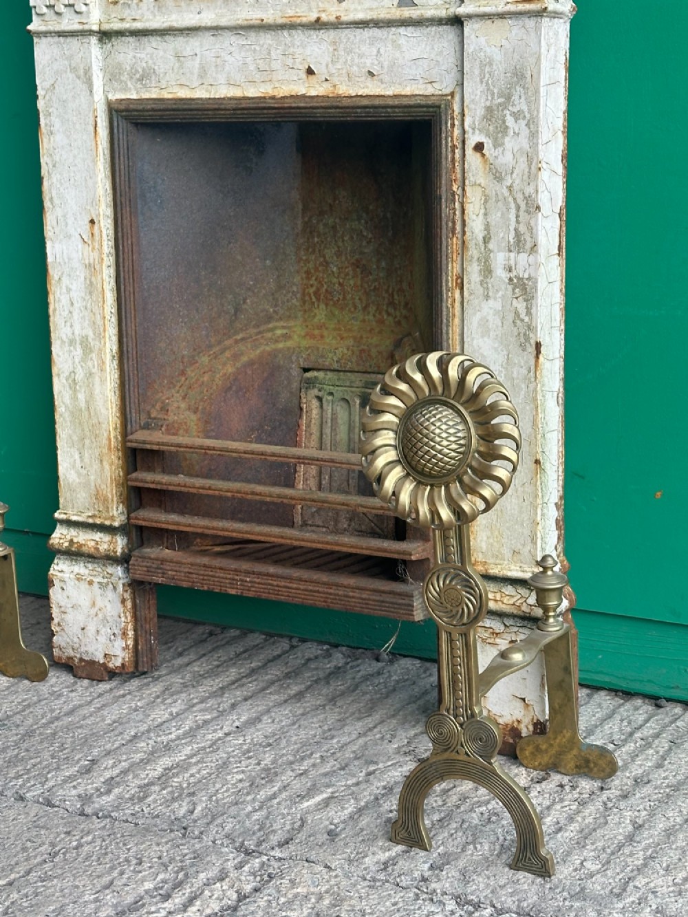 A pair of late Victorian cast brass andirons featuring stylised sunflower tops and geometric scroll detailing. View VIII